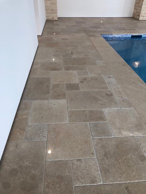 Close view of the natural stone floor laid beside an indoor pool