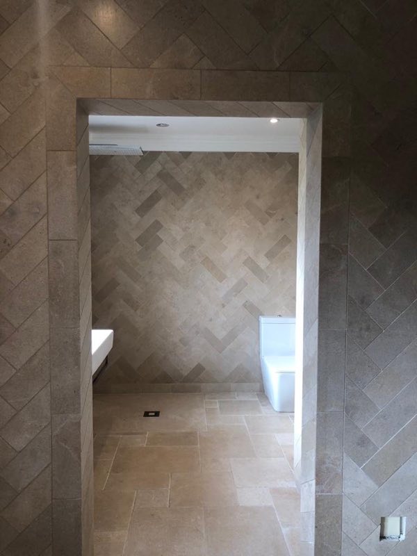 Shower room tiled in a herringbone pattern