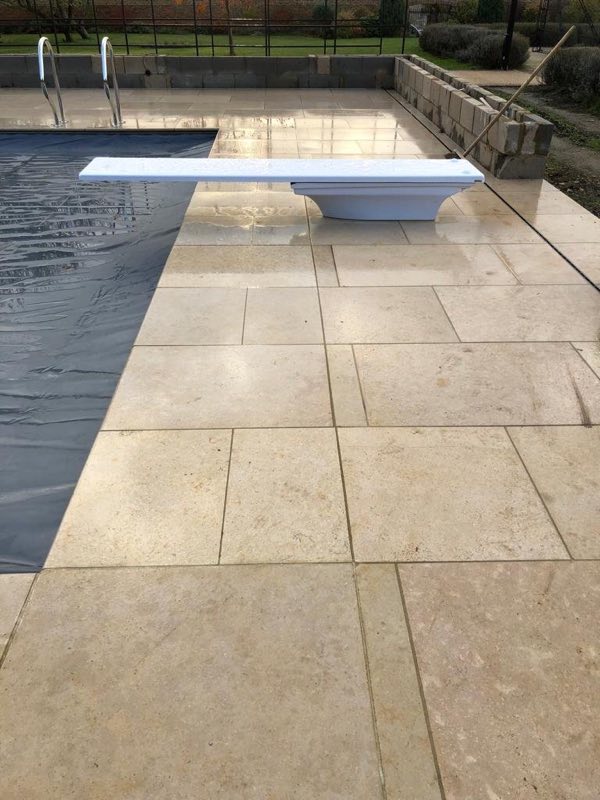 Diving board on the stone surround of an outdoor pool