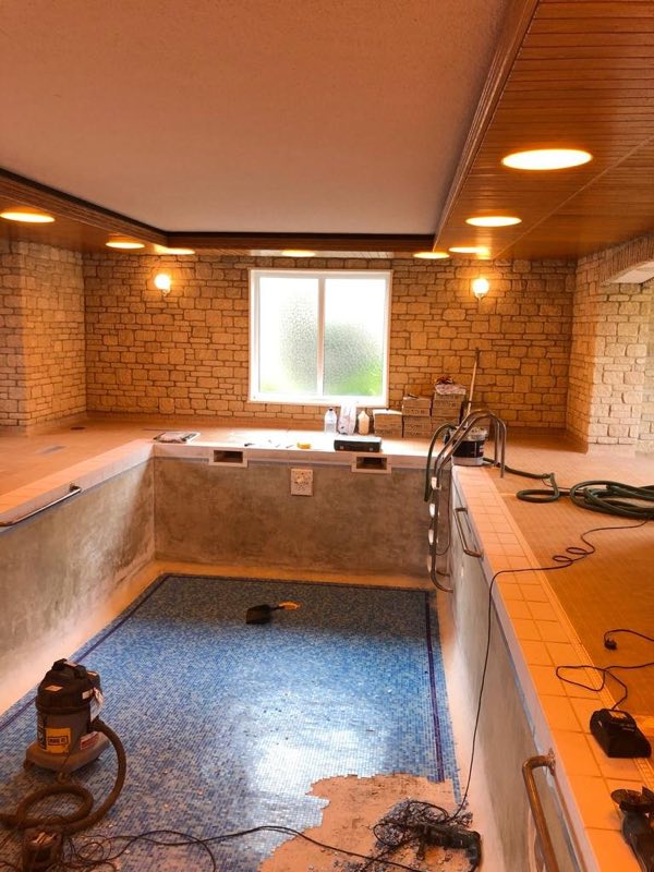 Indoor pool with the walls stripped back and the mosaic floor still in place