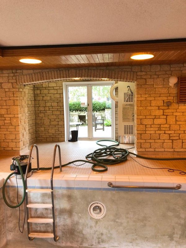 Drained indoor pool with the ladder in place, during renovation